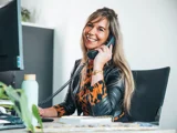 Telefoniste vrouw lachend met telefoon