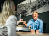 Service manager overhandigt een autosleutel aan een klant