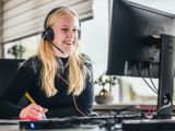 Klantenservice dame aan het lachen achter computer met headset