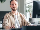 Marketeer man in kantoor achter computer