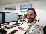 ICT beheerder lachend achter computer