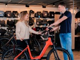 Damesfiets Groeneveld Fietsen verkoper en klant met rode fiets