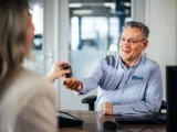 Ames service adviseur en een klant sleuteloverdracht