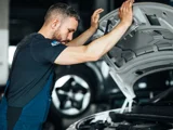 Ames Volkswagen monteur kijkt naar open motorkap