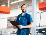 Service Adviseur Volvo lachend met iets in zijn handen