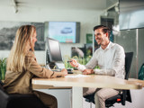 Man en vrouw in overleg bij een tafel in Ames Skoda showroom