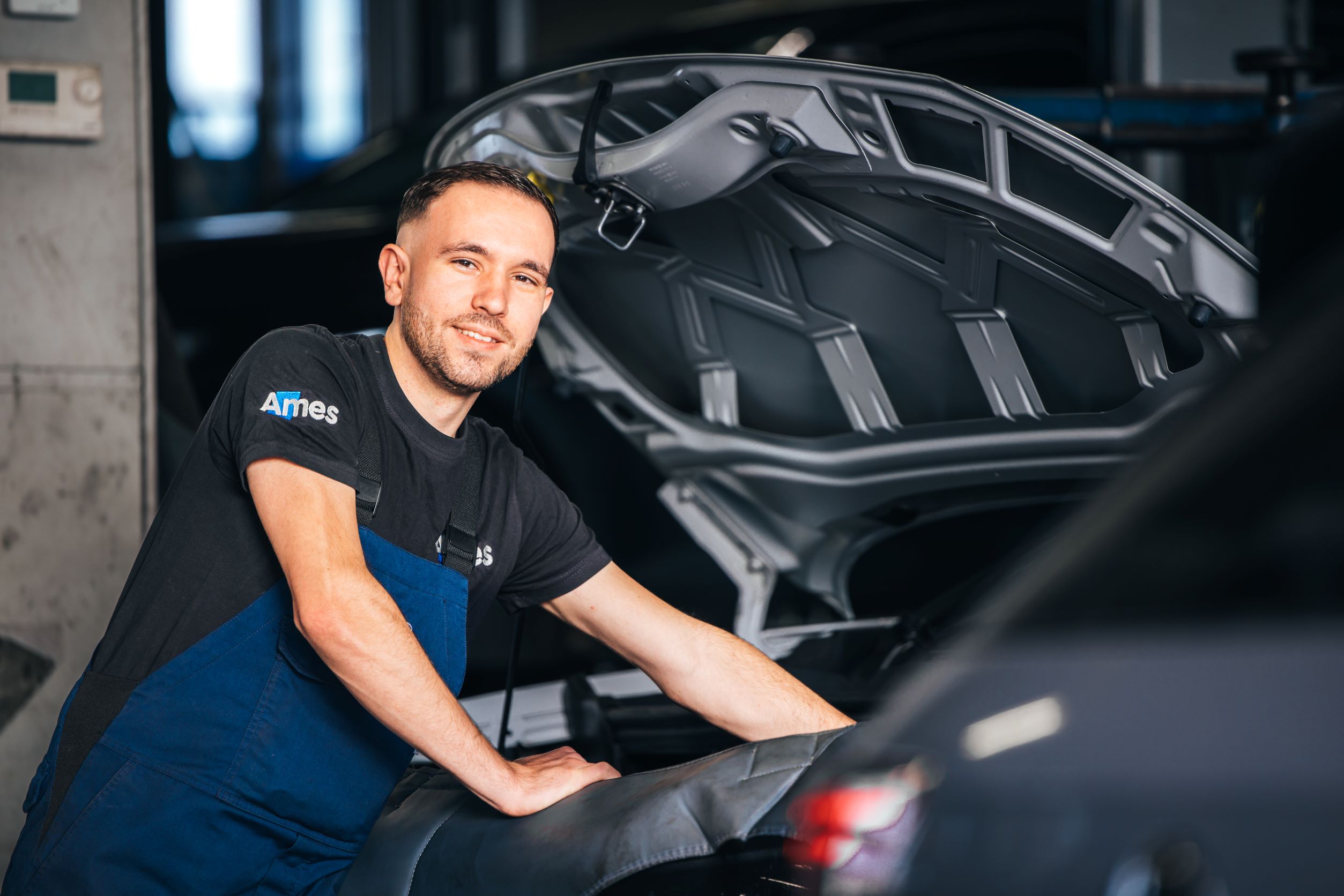 Ames monteur bij motorkap bezig