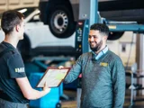 Opel van Mill Service Adviseur twee mannen sprekend documenten in handen