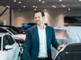 Audi verkoper aan het instappen in een witte auto in de showroom
