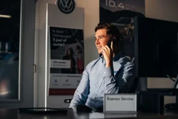 Service Adviseur Ames man bellend in de zon naar buiten kijkend